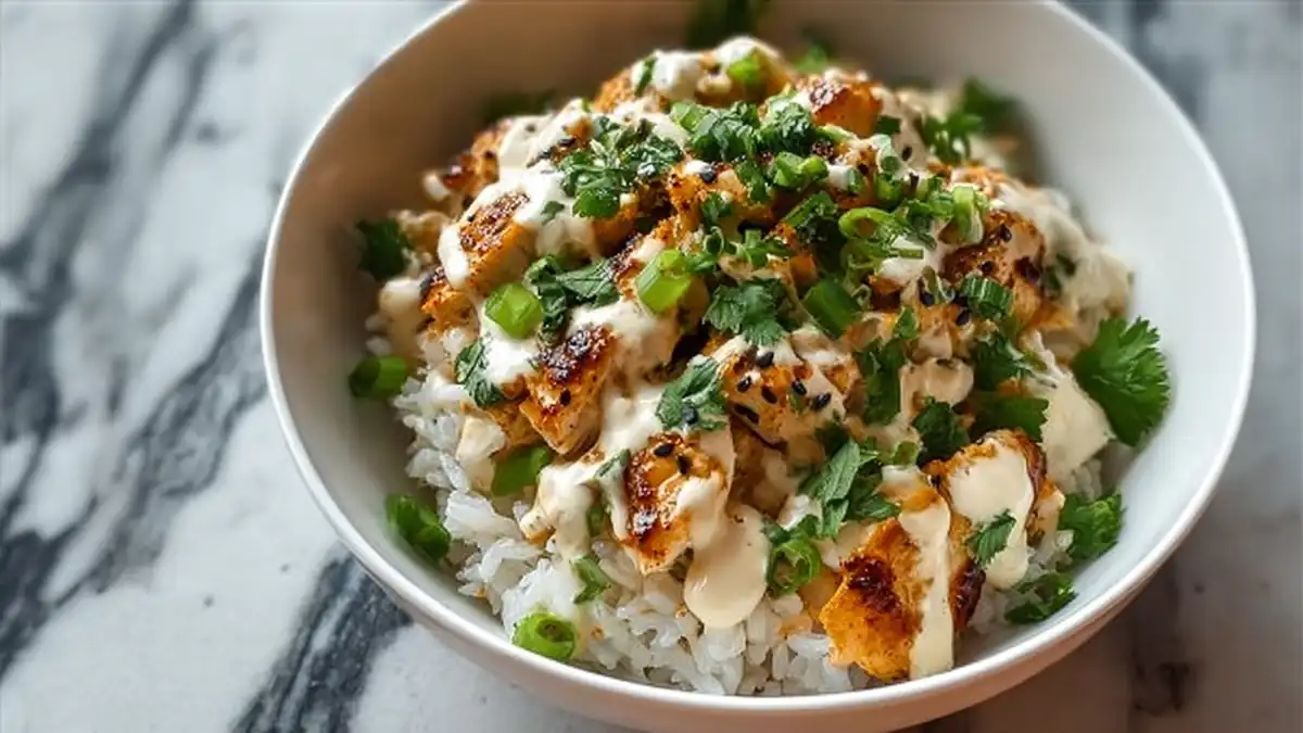 grilled chicken rice bowl with creamy sauce, fresh cilantro, green onions