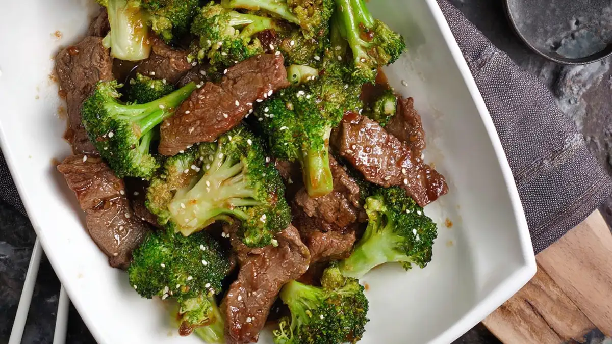 bowl of beef and broccoli stir-fry with sesame seeds in savory sauce