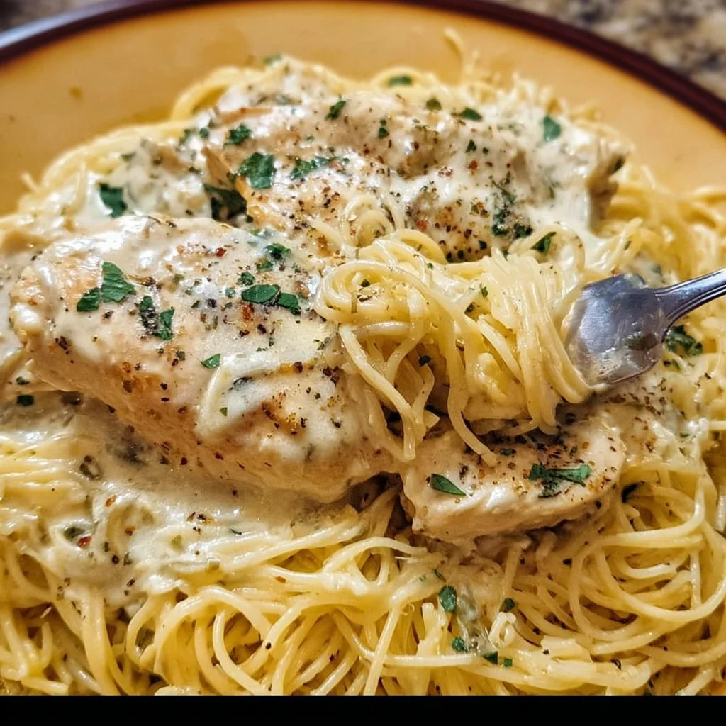 Delicious Crock Pot Angel Chicken served on a plate with herbs.