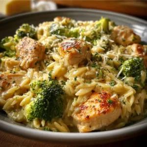 Cheesy Chicken and Broccoli Orzo served in a bowl, garnished with herbs.