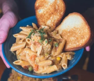 Crock Pot chicken pot pie pasta served in a bowl, garnished with herbs.