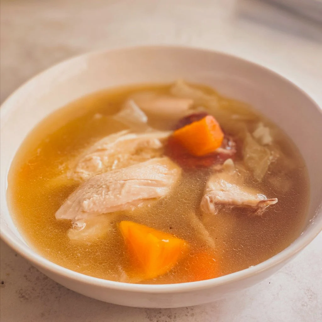 Bowl of no-water Chinese chicken soup served with herbs and vegetables