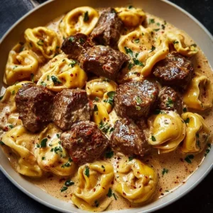Creamy One Pan Steak Tortellini served in a skillet with herbs and spices