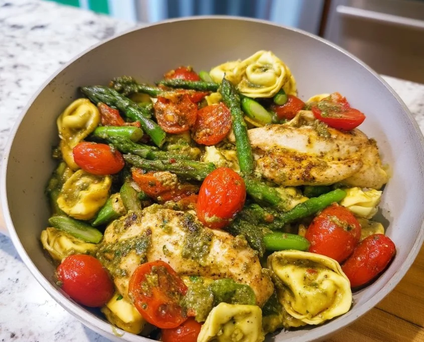 Crispy one-pan pesto chicken tortellini served with a fresh garnish